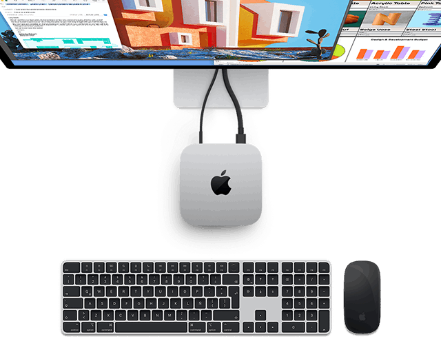 Vista desde arriba de una Mac mini color plata con el logo de Apple conectada a un monitor junto a un Magic Keyboard y un Magic Mouse inalámbricos